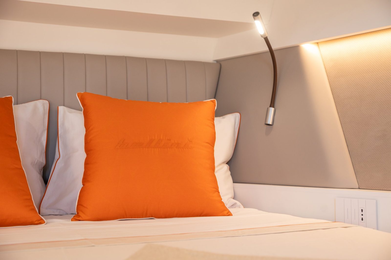 Bedhead with reading lights and orange cushions